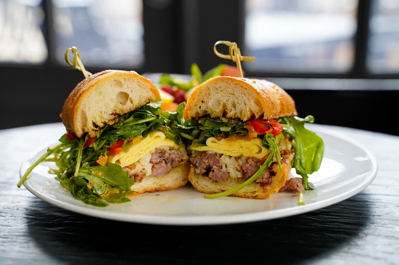 october breakfast sandwich collaboration with Sammy's at eden for brunch in chicago with arugula, egg, and crumbled italian breakfast sausage, and housemade torpedo roll